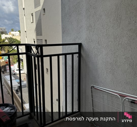 מעקה ברזל שחור מותקן במרפסת דירה בבניין מגורים
